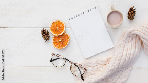 Workspase with notebook, glasses, cozy scarf and cup of coffee with milk on white wooden background. Autumn creative composirion flat lay. Work, online education, goals to do list, home office concept photo