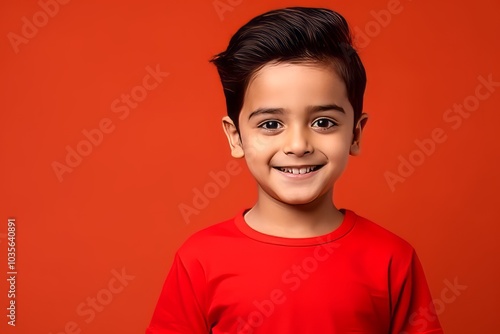 Portrait of a cute little boy on a red background with copyspace