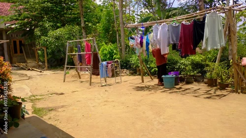 Wallpaper Mural A woman is seen drying clothes during the day under the hot sun.  Torontodigital.ca