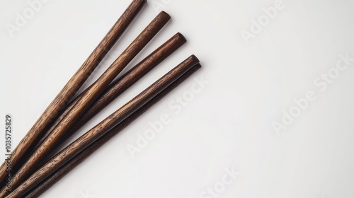 Four wooden chopsticks arranged neatly on a white background.