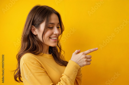 Pretty young woman over isolated yellow wall pointing finger to the side