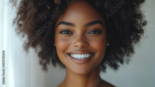 portrait of a smiling african american woman with an afro hairstyle set against a stark white background highlighting her joyful expression and natural beauty