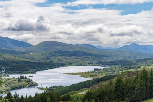 Cloudscape with high level view over lake Loch Garry and surrounding green mountains in Northwest Highlands of Scotland near Invergarry, UK with Lake Garry bridge visible photo