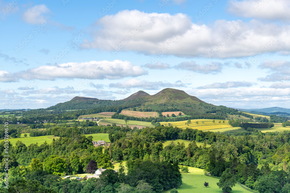 Fototapeta premium Panoramic westerly view from Scott's View near Melrose, UK over landscape near Scottish Borders, overlooking the valley of the River Tweed and the three peaks of the Eildon Hills