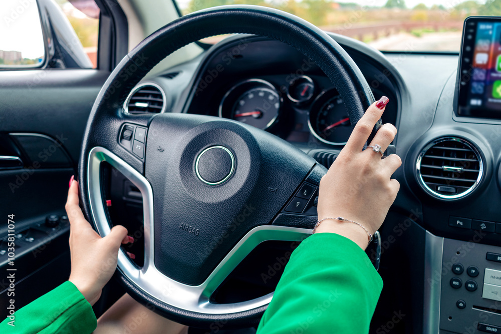 A girl in a green jacket driving a car. A girl in a green jacket driving a car.