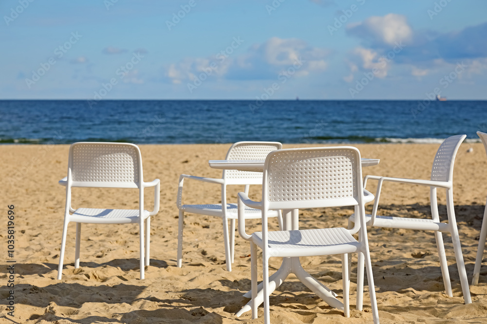 Fototapeta premium Empty seats of an outdoor cafe on an empty beach in the city of Sopot, Poland