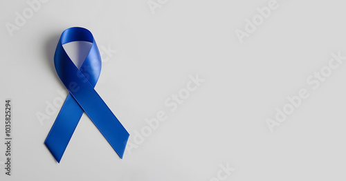 Blue awareness ribbon isolated on blue background. World diabetes day, 14 november, prostate cancer awareness banner. Blue November, International Men's Day concept with copy space