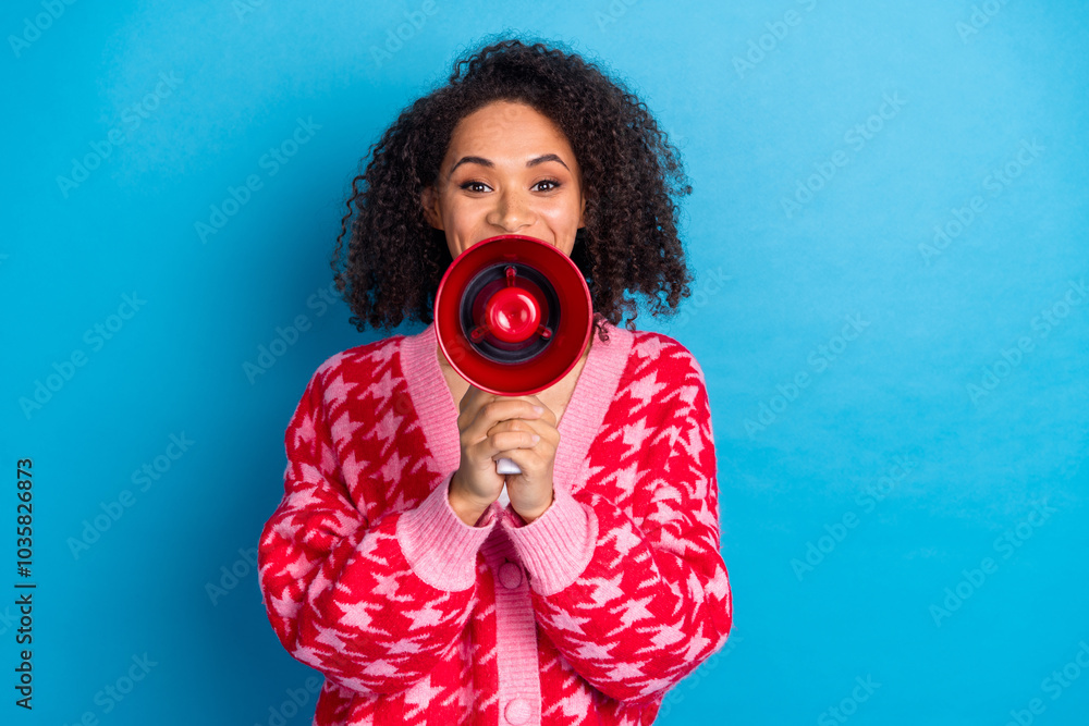 Obraz premium Portrait photo of american beautiful girl with curly hair wearing red stylish cardigan hold megaphone isolated on blue color background