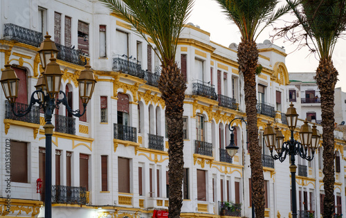 Beautiful colonial facade In Tangier, Tanger, Morocco. white, yellow. Street lamp. Palm trees.