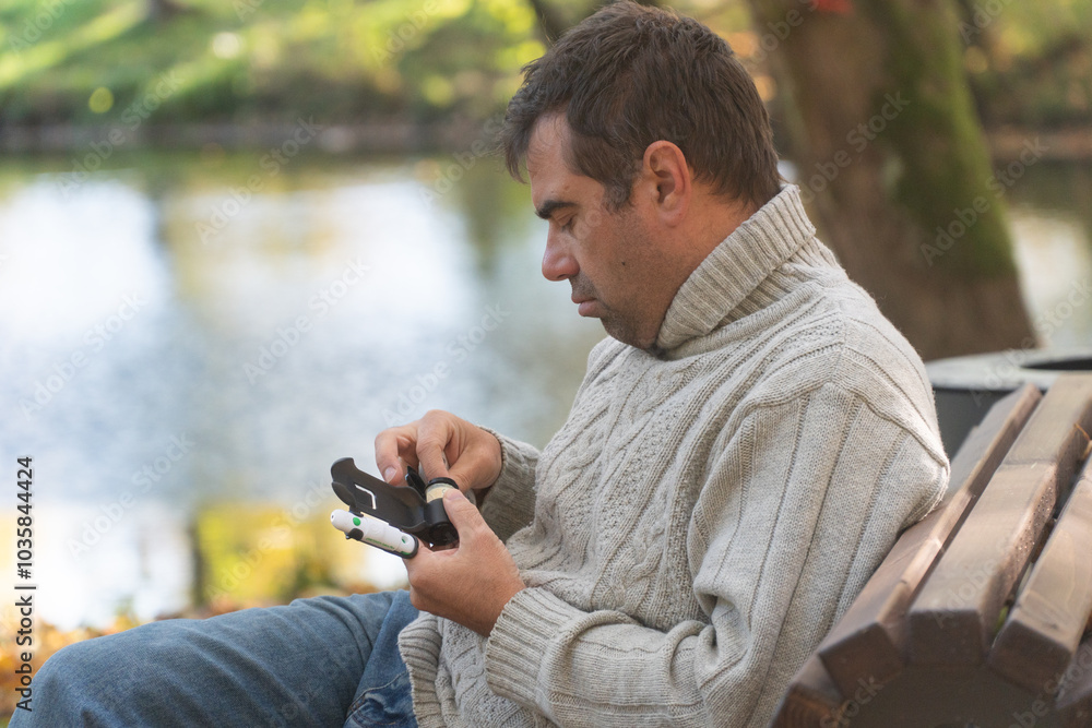 man walks through the forest and sits on a stump, he measures his blood sugar, diabetes, diabetes disease man walks through the forest and sits on a stump, he measures his blood sugar, diabetes, diabetes disease