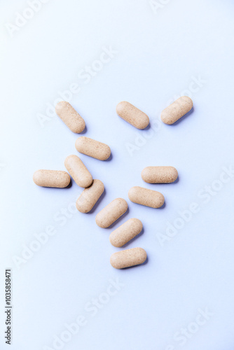 Ashwagandha (Withania somnifera) tablets on paper background. Soft focus. Close up. Copy space. 