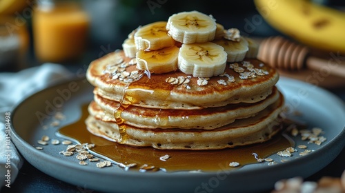 Delicious stack of pancakes topped with sliced bananas and drizzled with syrup.