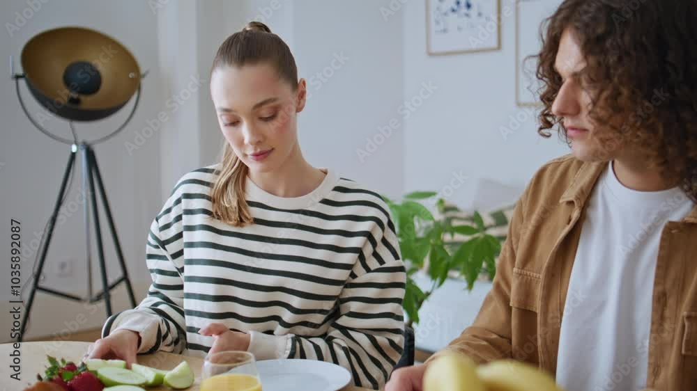 Couple enjoy family breakfast at kitchen table closeup. Two people preparing eat Couple enjoy family breakfast at kitchen table closeup. Two people preparing eat