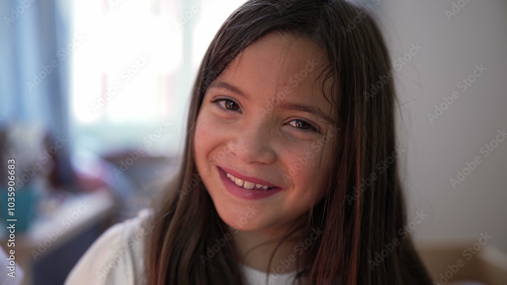 Portrait of young girl smiling at the camera, showing happiness and innocence in a home setting, with natural expression Portrait of young girl smiling at the camera, showing happiness and innocence in a home setting, with natural expression