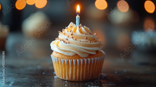 A beautifully decorated cupcake with a lit candle, creating a festive and warm atmosphere.