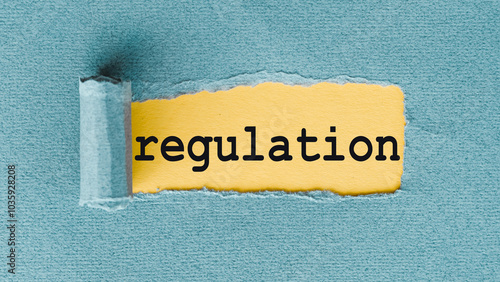 The word regulation is written in black on a yellow piece of paper, which is partially torn to reveal a blue background.