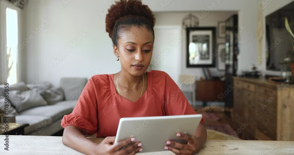 Pretty African woman using tablet sit at table in living room, chatting online, choose and buy goods, electronic services via marketplace application, watch videos on platforms, spend time on internet Pretty African woman using tablet sit at table in living room, chatting online, choose and buy goods, electronic services via marketplace application, watch videos on platforms, spend time on internet