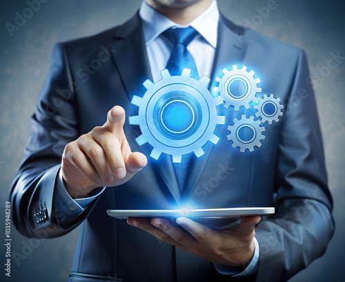 A businessman holds a tablet and interacts with digital gears floating above, representing the integration of technology in managing business processes and innovation. photo