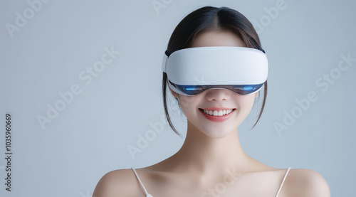 woman smiling while wearing VR headset against grey background, showcasing modern technology and virtual reality