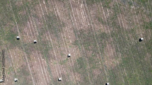 Drone Aerial footage of hay stacks on a field straight from above