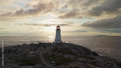 Stunning Aerial View Of Peggy's Cove Lighthouse On A Rocky Shore As The Sun Sets Over The Atlantic Ocean, Creating A Beautiful Scenic View Near Halifax, Nova Scotia.