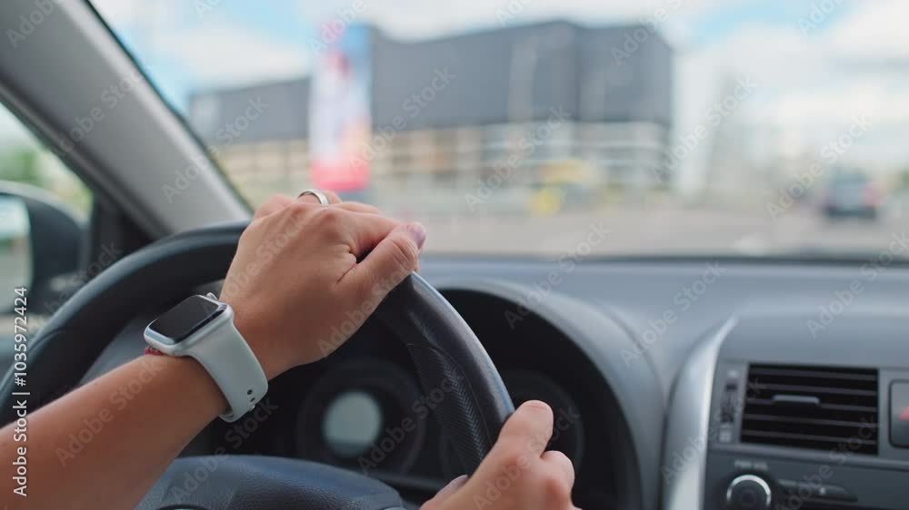 Close-up of female hands on the steering wheel of a car. A girl drives a car on city streets with traffic. High quality 4k footage Close-up of female hands on the steering wheel of a car. A girl drives a car on city streets with traffic. High quality 4k footage