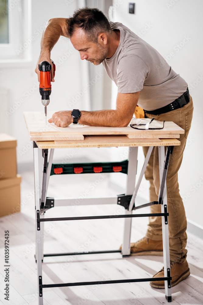 a handsome man making furniture in his new apartment a handsome man making furniture in his new apartment