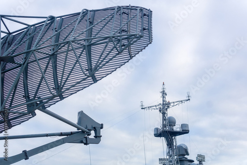 military background, naval radar antenna close up and warship in the background photo