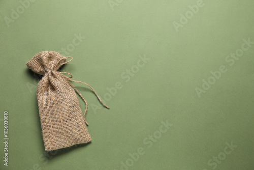 One burlap sack on olive background, top view. Space for text