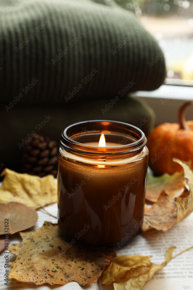 Burning candle and dry leaves on open book. Autumn atmosphere Burning candle and dry leaves on open book. Autumn atmosphere