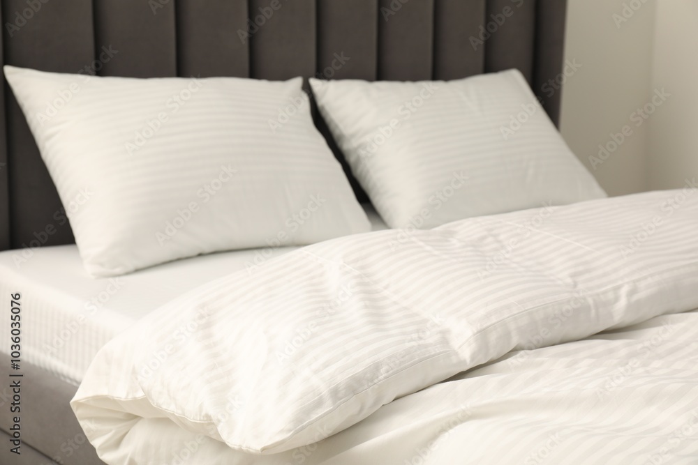 Comfortable bed with clean linens and pillows indoors, closeup Comfortable bed with clean linens and pillows indoors, closeup