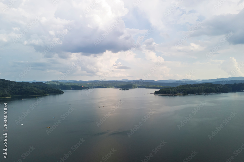 A scenic view of a tranquil lake reflecting the sky, surrounded by lush green hills. Perfect for nature lovers and landscape photography enthusiasts. A scenic view of a tranquil lake reflecting the sky, surrounded by lush green hills. Perfect for nature lovers and landscape photography enthusiasts.