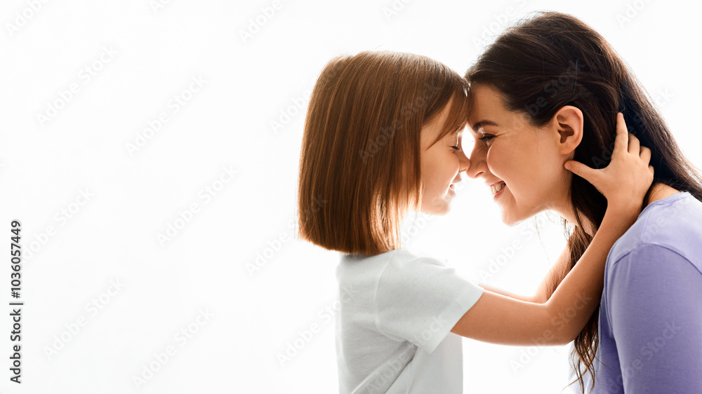 Close up of sweet pretty daughter cuddling with her young mother, white background, free space Close up of sweet pretty daughter cuddling with her young mother, white background, free space