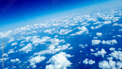 Aerial view of fluffy white clouds scattered across a deep blue sky.