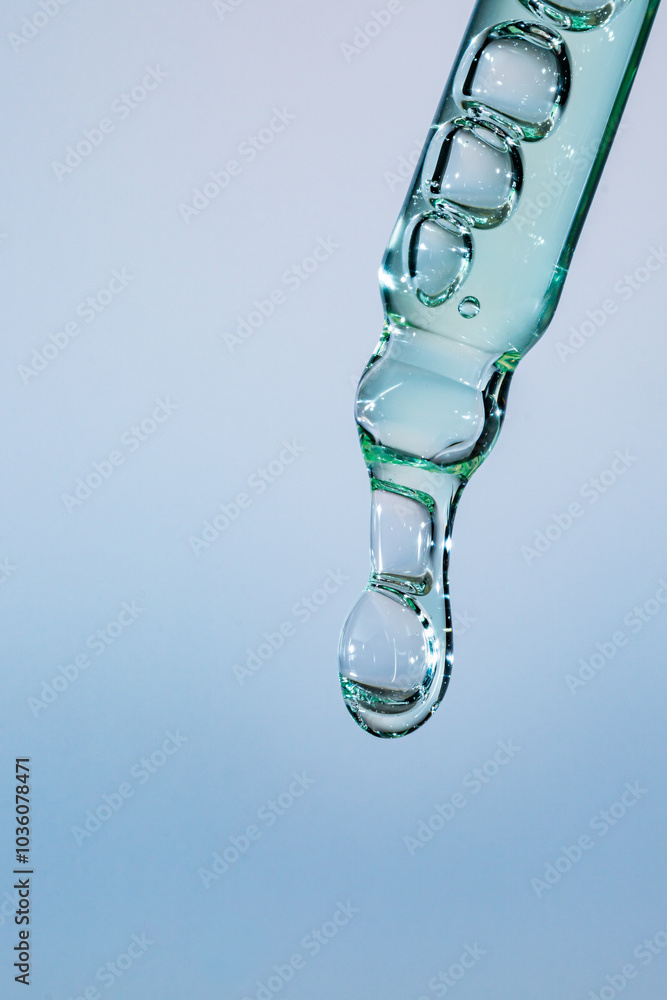 cosmetic dropper with bubbles close-up isolated on blue background cosmetic dropper with bubbles close-up isolated on blue background
