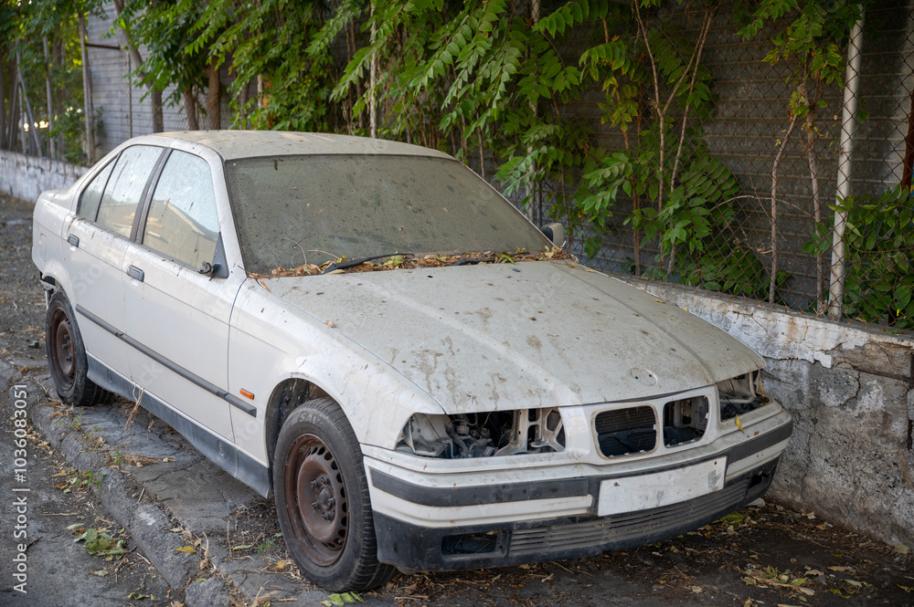 Abandoned and Damaged Car Covered in Dust and Leaves Abandoned and Damaged Car Covered in Dust and Leaves