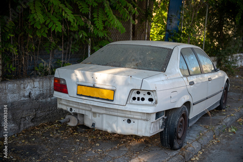 Abandoned and Damaged Car Covered in Dust and Leaves