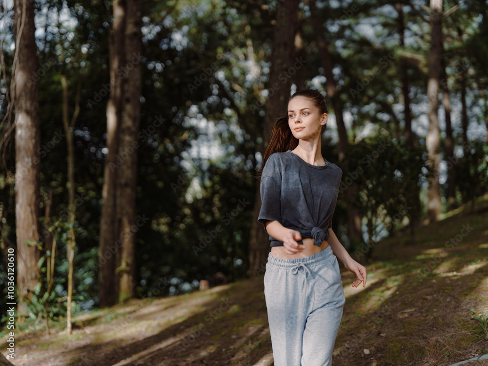 Young woman walking through a serene forest, dressed in casual grey attire, showcasing calm emotions and connecting with nature Peaceful and refreshing atmosphere Young woman walking through a serene forest, dressed in casual grey attire, showcasing calm emotions and connecting with nature Peaceful and refreshing atmosphere