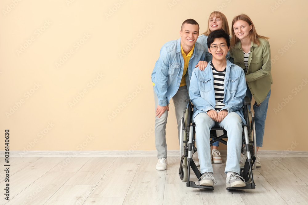 Group of teenagers with boy in wheelchair near beige wall Group of teenagers with boy in wheelchair near beige wall