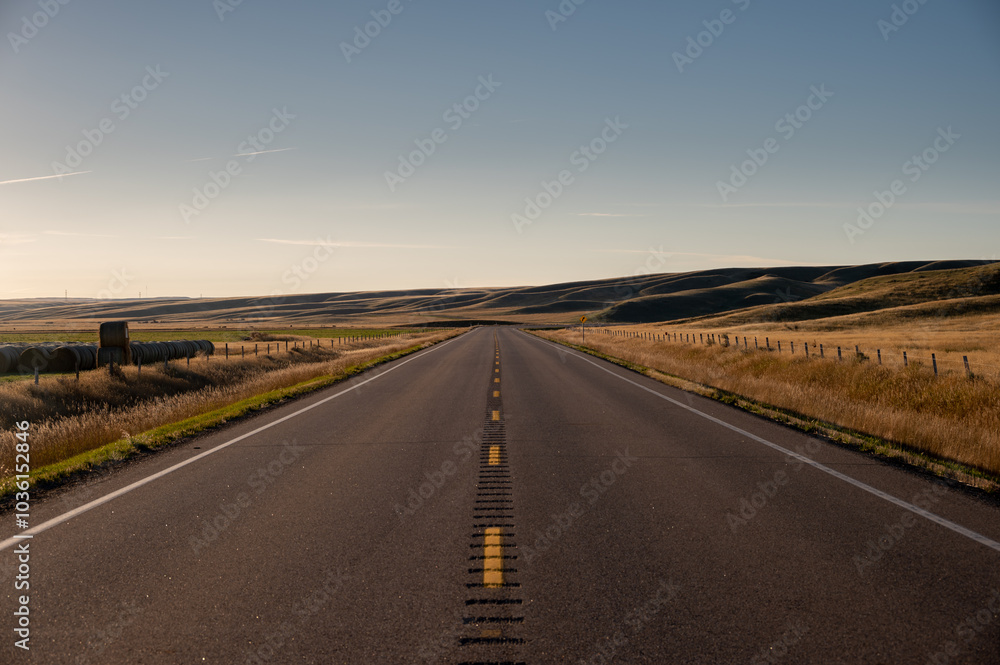 Fototapeta premium Sunrise highway in the badlands of Southern Alberta.
