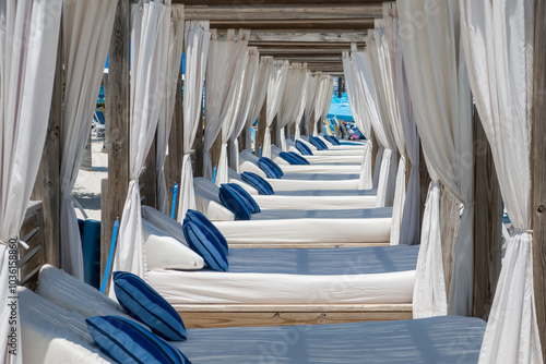Fototapeta Naklejka Na Ścianę i Meble -  Row of cabanas with beds and pillows at a beach luxury resort.