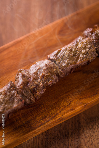 Close-Up of Grilled Beef Skewer on Wooden Board