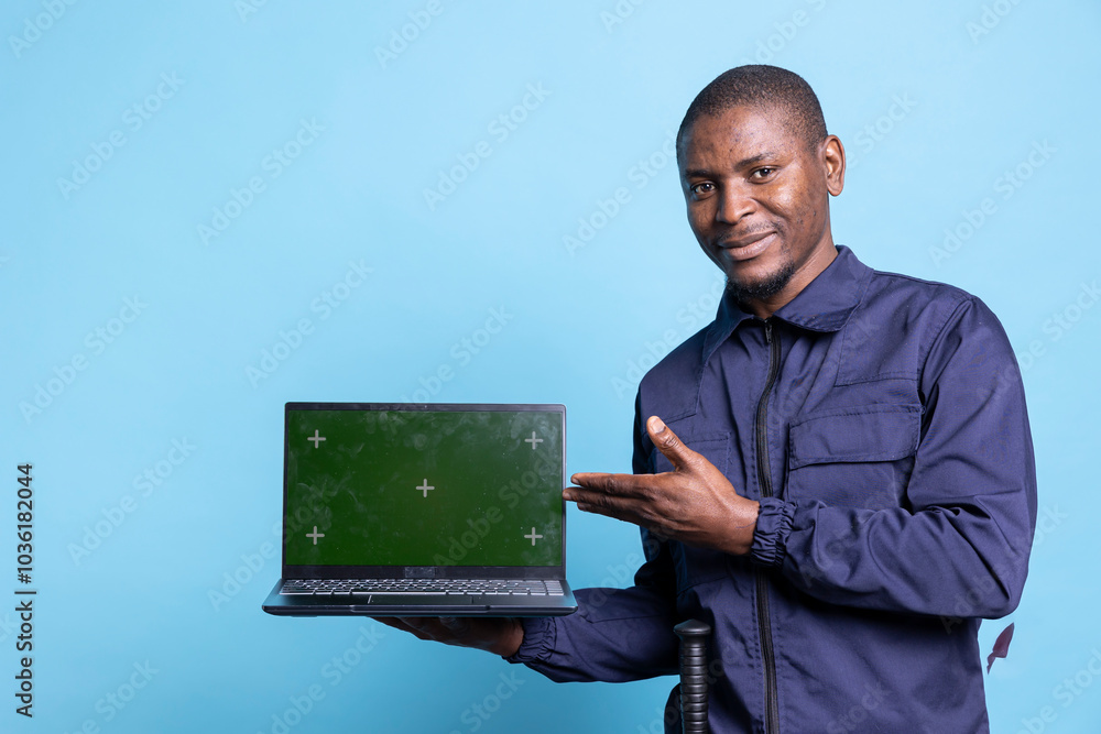 Smiling security guard pointing at his laptop with isolated copyspace ...