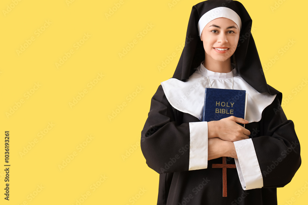 Young nun with Bible on yellow background Young nun with Bible on yellow background