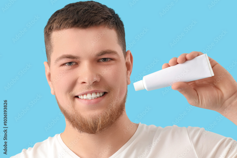 Smiling young bearded man with toothpaste on blue background, closeup Smiling young bearded man with toothpaste on blue background, closeup