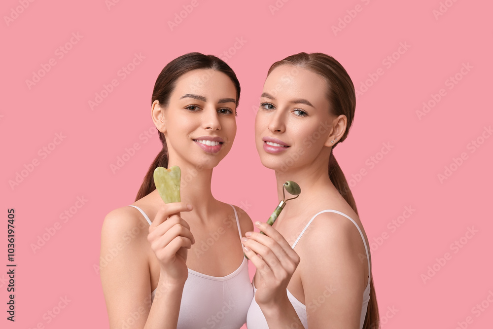 Beautiful young happy women with healthy skin, facial massage and guasha tools on pink background Beautiful young happy women with healthy skin, facial massage and guasha tools on pink background