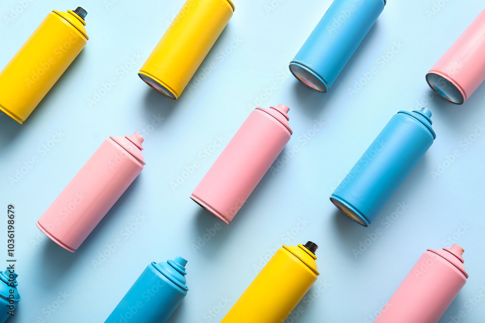Different spray paint cans on blue background Different spray paint cans on blue background