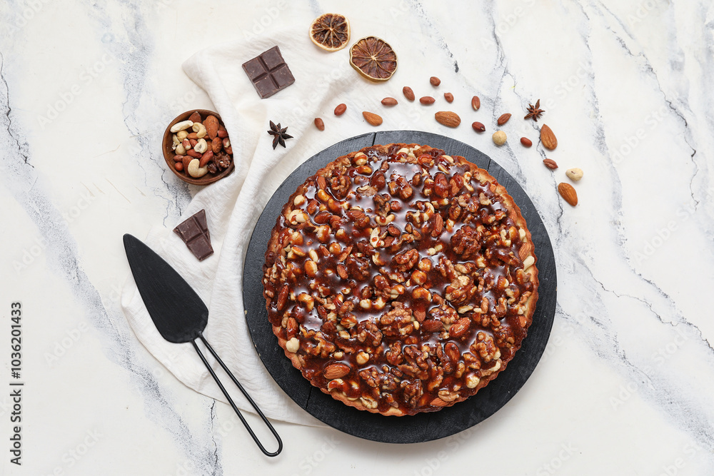 Black board of sweet tart with different nuts and ingredients on white background Black board of sweet tart with different nuts and ingredients on white background