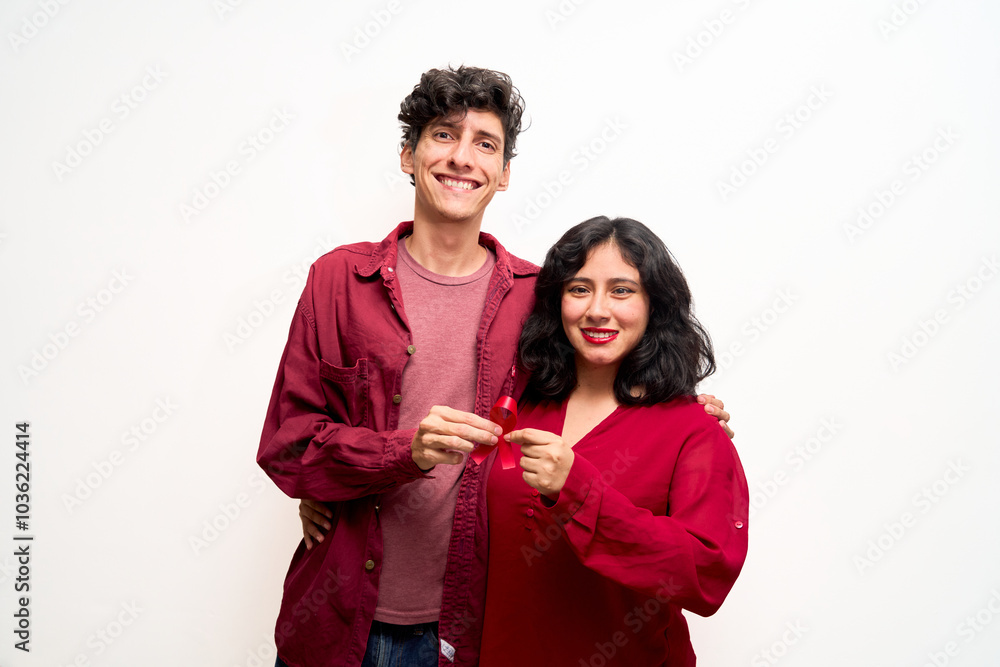 Young Latin couple, holds red ribbon for World AIDS Day Young Latin couple, holds red ribbon for World AIDS Day