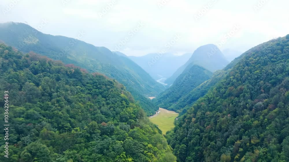 A picturesque mountain valley surrounded by towering green mountains under a bright blue sky. The idyllic scenery evokes a sense of adventure and peacefulness in nature. A picturesque mountain valley surrounded by towering green mountains under a bright blue sky. The idyllic scenery evokes a sense of adventure and peacefulness in nature.